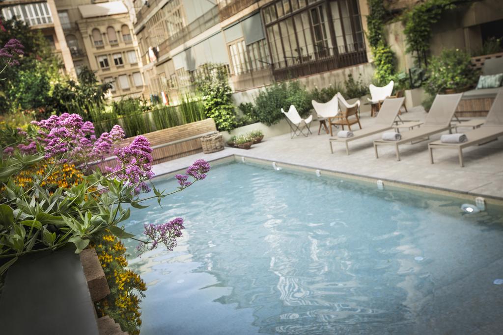 Quiet outdoor swimming pool and terrace garden area at the Alexandra Barcelona Hotel