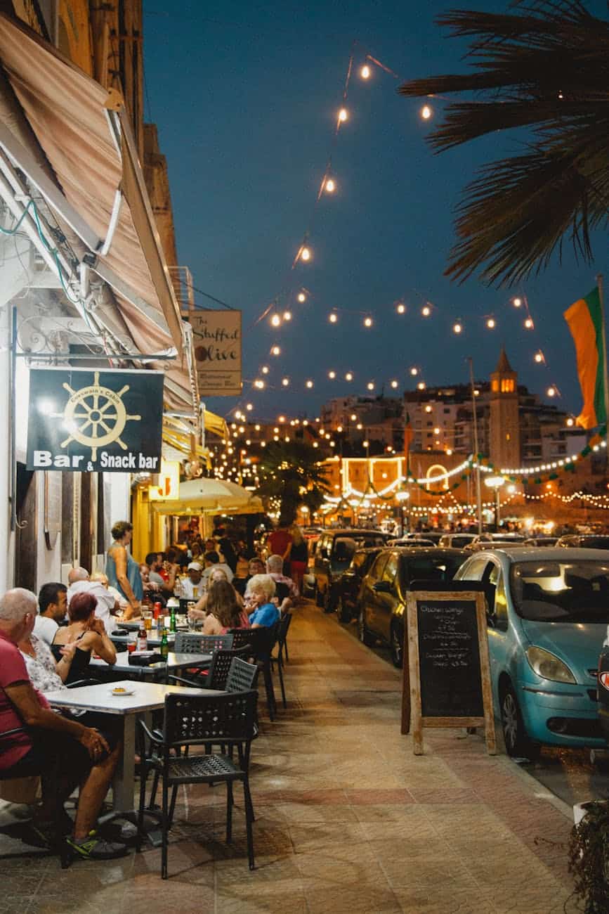 Travelers enjoying a late-night meal at a vibrant Mediterranean street cafe, showcasing the local evening atmosphere for cruise guests.